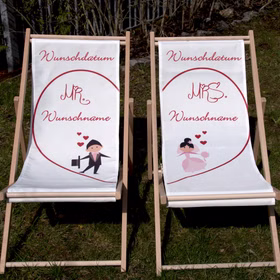 Zwei personalisierbare Mr. & Mrs. Hochzeits-Liegestühle mit Wunschdatum und Wunschname stehen im Garten.