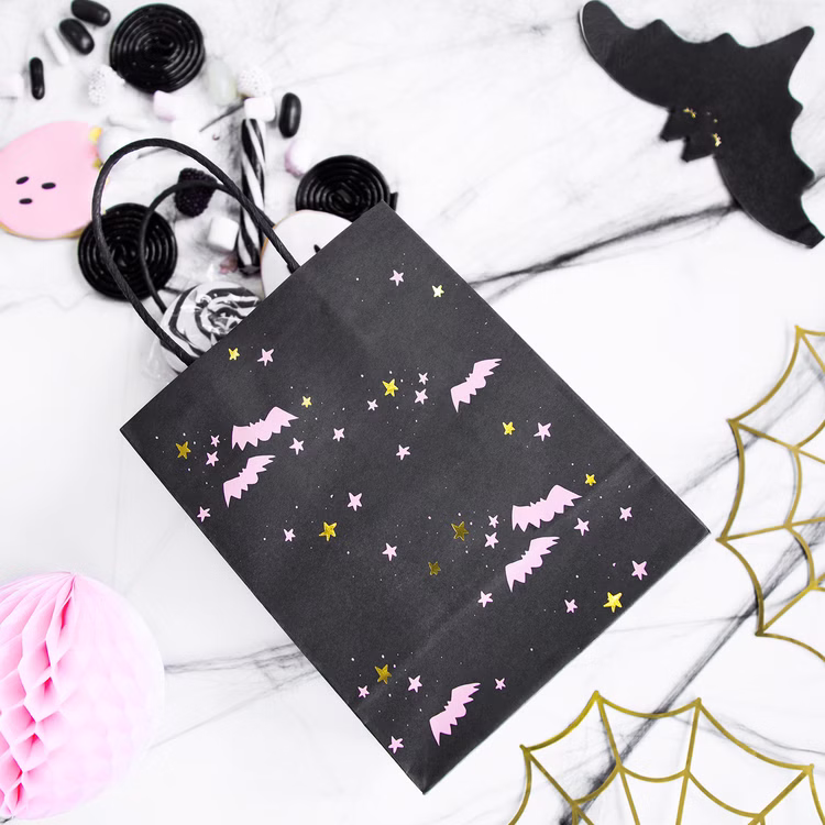 Halloween Geschenktüte Fledermäuse Schwarz Roségold 14 x 18 cm Party-Deko SALE Tisch-Deko Kindergeburtstag Mottoparty Halloween Party Dekoration Mitgebsel Halloween-Geschenktüte mit Fledermausmotiv gefüllt mit Süßigkeiten und Dekoration auf einem festlich dekorierten Tisch.
