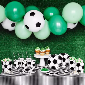 Komplett dekorierter Fußball-Partytisch mit Ballongirlande, Tellern, Bechern und Servietten.