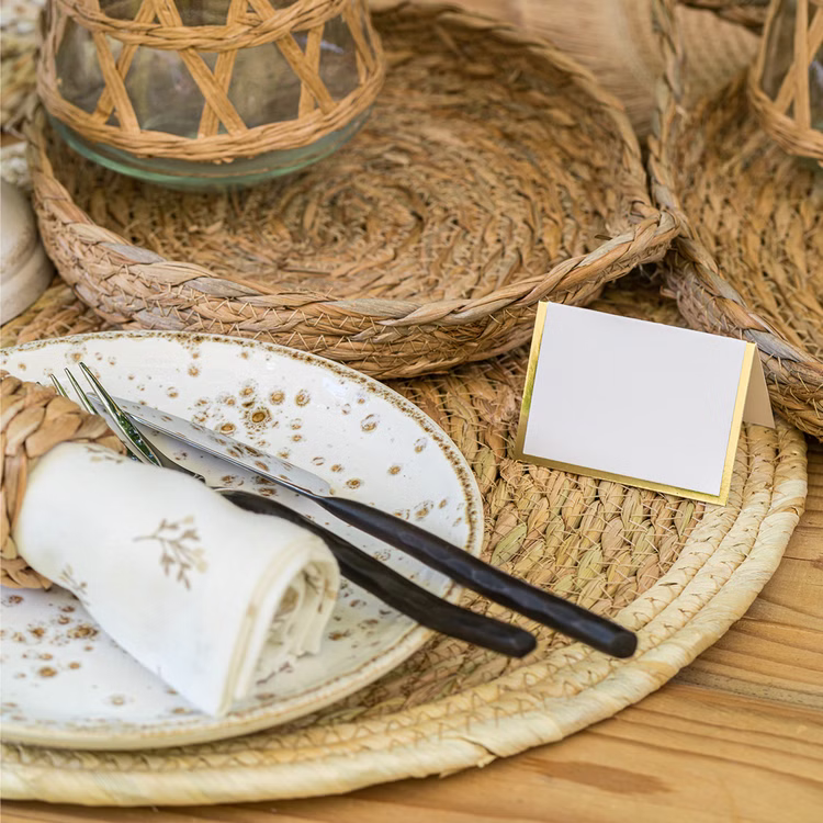 Platzset Stroh Naturfarben Tischdekoration Naturfarbenes Platzset aus geflochtenem Stroh als Tischdeko mit Teller, Besteck, Serviette und Tischkärtchen im Boho-Stil.