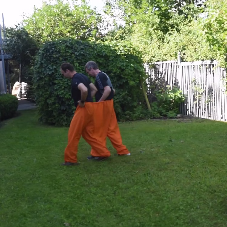 Doppelhose Orange Hose mit drei Hosenbeinen Party-Spaß Hochzeit Geburtstag Partyspiel Fasching Karneval Mottoparty Wettrennen im Garten mit orangefarbener Doppelhose von der Seite