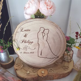 Baumscheibe mit Gravur Lotte & Philipp 13. Januar 2018 mit Doppelherzen und Brautpaar-Motiv.