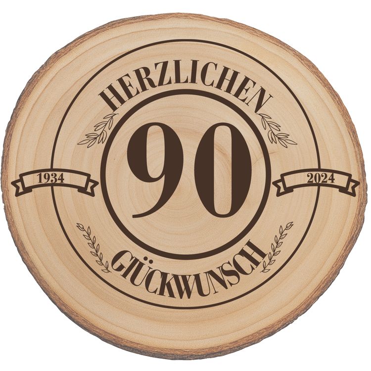 Baumscheibe Herzlichen Glückwünsch mit Wunschzahl-Gravur 30 cm Geburtstag Glückliche ältere Frau mit Familie bei der Geburtstagsfeier, im Vordergrund eine Baumscheibe mit Gravur „Herzlichen Glückwunsch 90“.