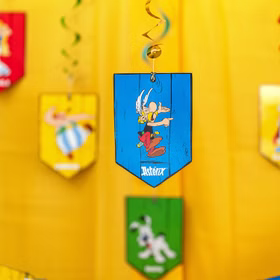 Blauer Spiral-Deckenhänger mit Asterix-Motiv vor gelbem Hintergrund als dekorative Party-Raumgestaltung.