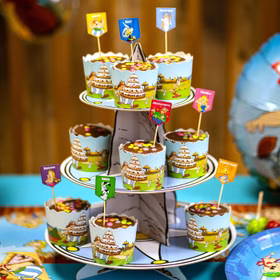 Mehrstöckiger Cupcake-Ständer mit Asterix-Muffinformen und dekorativen Figurensteckern für eine Comic-Mottofeier.