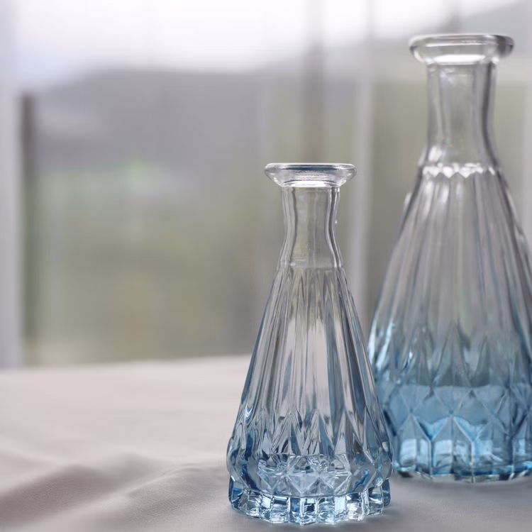 Mini Vase Alexandrin Glasvase 10,7 cm Farbverlauf Blau Tisch-Deko Hochzeit Geburtstag Blumenvase dekorative Vase gedeckter Tisch Zwei Glasvasen in verschiedenen Größen, klar-blau, auf weißem Tischtuch.