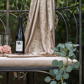 Festliche Tischdekoration mit altrosa Rose, Champagner und Gläsern.