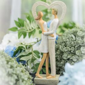 Brautpaar Figur Stehend Liebe Weiß mit Herz Tischdeko Hochzeits-Deko Tisch-Deko Deko-Ideen Geschenkidee Braut & Bräutigam Figur eines Paares im Herzrahmen, aufgestellt zwischen grüner und blauer Blumendeko.