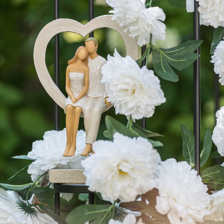 Brautpaar Figur Sitzend Liebe Weiß mit Herz Tischdeko Hochzeits-Deko Figur eines Brautpaars im weißen Herzrahmen, sitzend auf einem Sockel.