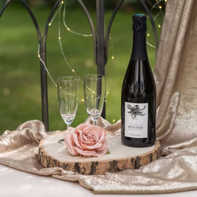 Dekorative Holz-Herzscheibe mit Rose und Sektgläsern dekoriert.