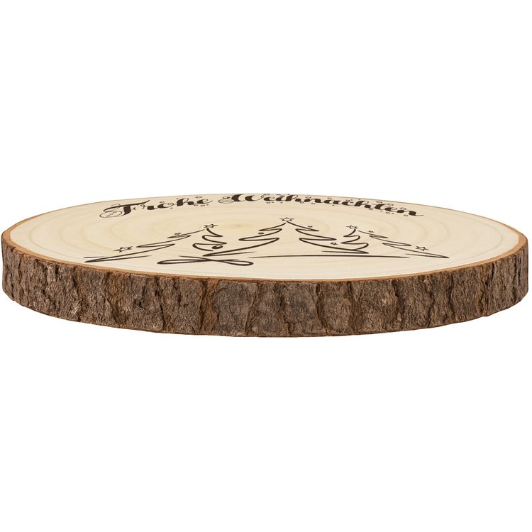 Große Baumscheibe mit Gravur, eingebettet in ein festliches Arrangement aus Tannenzweigen, goldenen Kugeln, Teelichtern und Kunstschnee, im Hintergrund warm leuchtende Bokeh-Lichter.