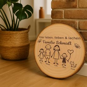 Personalisierte Holzscheibe als Deko-Element in einem modernen Wohnraum neben einer Backsteinwand und einer Zimmerpflanze.