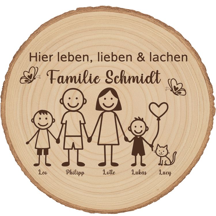 Baumscheibe 30 cm Familie Willkommensschild personalisiert mit Jungen & Katze Personalisierte Holzscheibe mit Familienmotiv lehnt an einer Backsteinwand neben einer grünen Zimmerpflanze in einem natürlichen Wohnraumambiente.