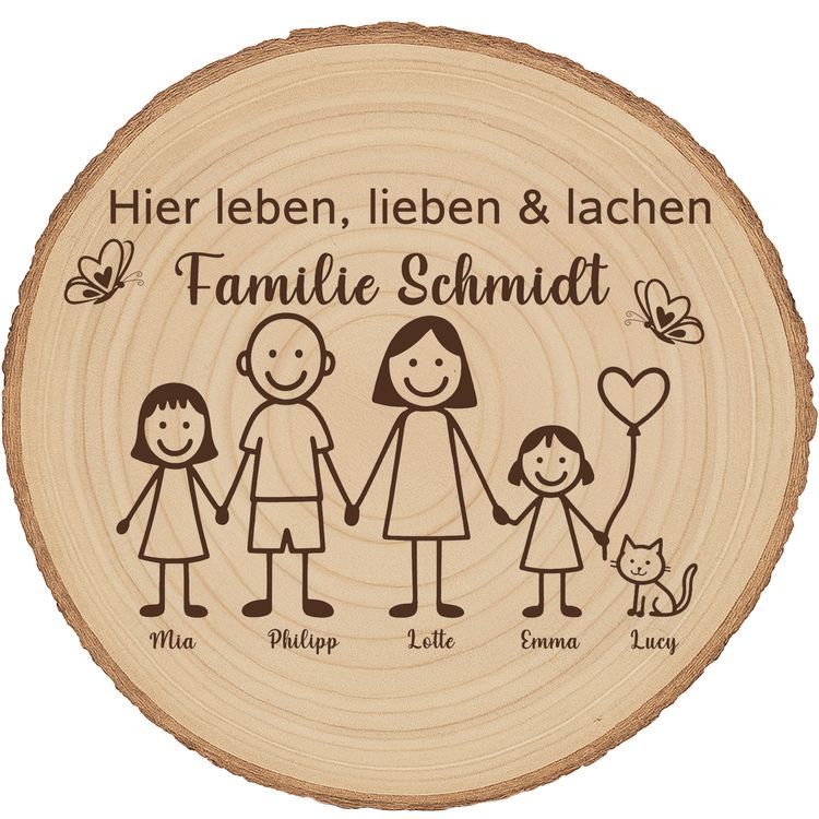 Baumscheibe 30 cm Familie Willkommensschild personalisiert mit Mädchen & Katze Personalisierte Holzscheibe mit Familienmotiv lehnt an einer Backsteinwand neben einer grünen Zimmerpflanze in einem natürlichen Wohnraumambiente.