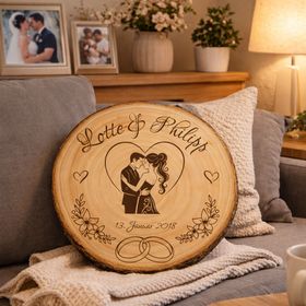 Personalisierte Holz-Baumscheibe als Hochzeitsgeschenk, dekoriert mit Kerzen, Rosen und Spitze auf einer festlichen Tischdekoration.