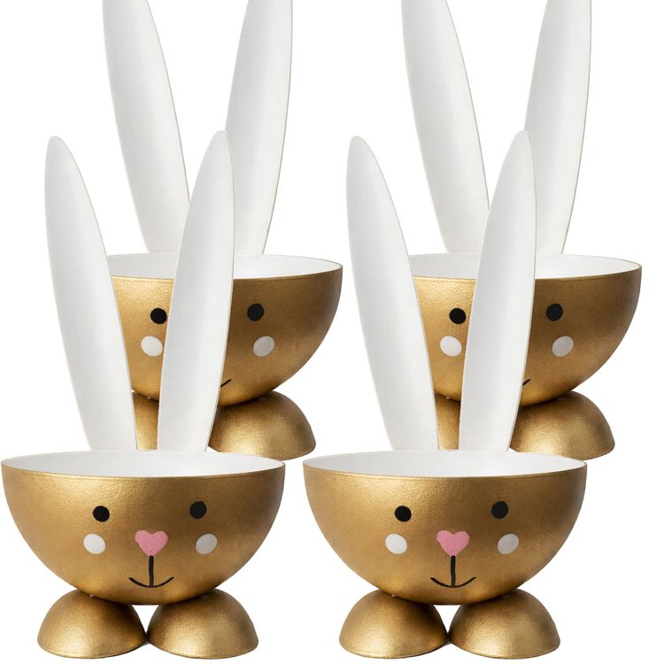 Eierbecher-Set 4 Stück Hase Gold aus Metall Osterhase gedeckter Tisch Ostern Vier goldfarbene Eierbecher in Hasenform aus Metall mit weißen Ohren und rosa Herz-Nase, frontal auf weißem Hintergrund angeordnet; rechts unten Hinweis 4 Stück.
