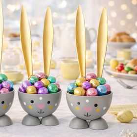 Sechs graue Hasen-Eierbecher mit goldenen Ohren auf weißem Hintergrund; unten rechts befindet sich ein runder Hinweis mit der Aufschrift „6 Stück“.