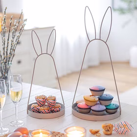 Oster-Deko Serviertablett 2er-Set mit Hasenohren 49 cm & 39 cm Schale aus Metall Hasenohren Deko-Etagere (1-stufig) Osterdeko Ostern Osterfest Dekoration Zwei Metall-Serviertabletts mit Hasenohren in 39 cm und 49 cm Höhe auf einem hell gedeckten Tisch, dekoriert mit Muffins und Frühlingszweigen.