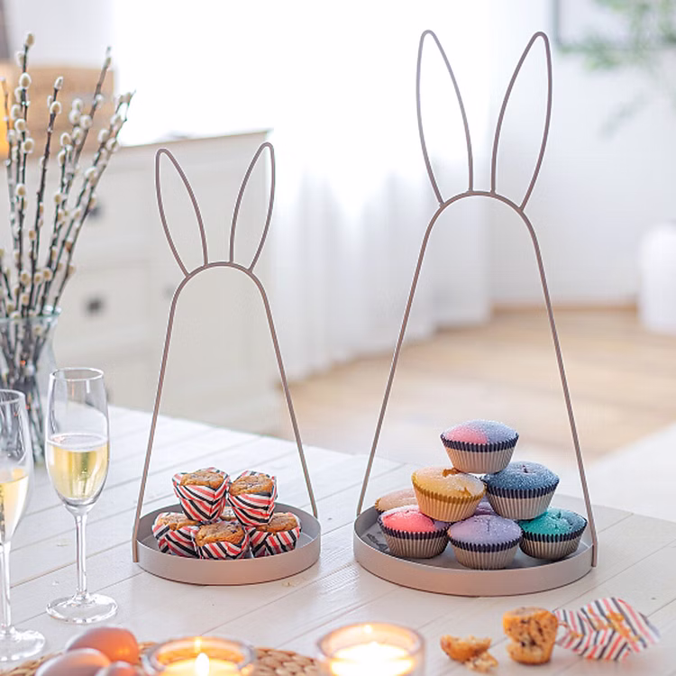 Oster-Deko Serviertablett 2er-Set mit Hasenohren 49 cm & 39 cm Schale aus Metall Hasenohren Deko-Etagere (1-stufig) Osterdeko Ostern Osterfest Dekoration Zwei Metall-Serviertabletts mit Hasenohren in 39 cm und 49 cm Höhe auf einem hell gedeckten Tisch, dekoriert mit Muffins und Frühlingszweigen.