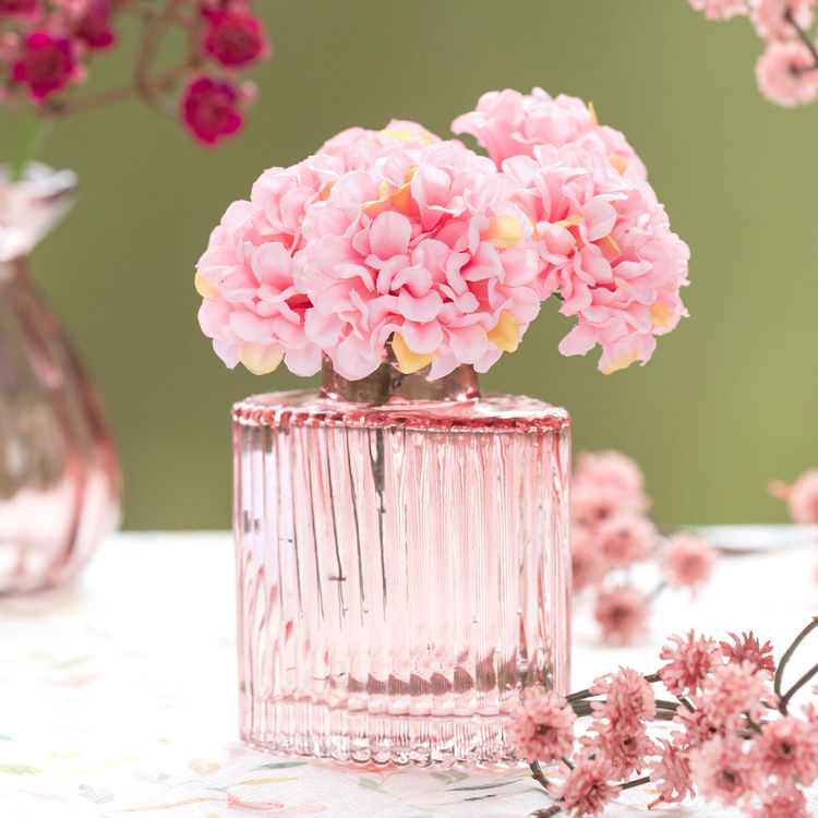 Mini-Glasvase „Helios“ in Rosa mit geriffelter Oberfläche, rechteckiger Form und kleiner Öffnung auf hellem Hintergrund.