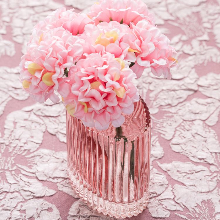 Mini-Glasvase „Helios“ in Rosa mit geriffelter Oberfläche, rechteckiger Form und kleiner Öffnung auf hellem Hintergrund.