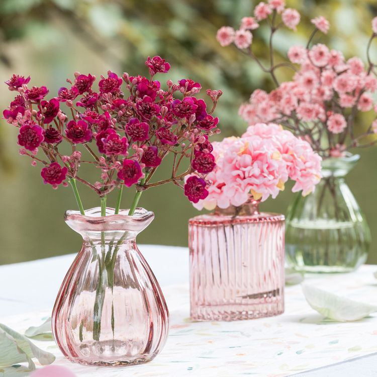 Drei rosa Glasvasen in unterschiedlichen Größen vor weißem Hintergrund.