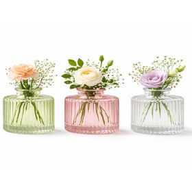 Drei Mini-Glasvasen in Rosa, Grün und Transparent mit geriffelter Oberfläche und unterschiedlicher Form auf hellem Hintergrund.