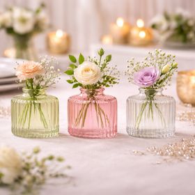 Drei Mini-Glasvasen in Rosa, Grün und Transparent mit geriffelter Oberfläche und unterschiedlicher Form auf hellem Hintergrund.