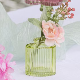 Mini Glasvasen-Set 6er Rosa Grün Klar Tisch-Deko Hochzeit Geburtstag gedeckter Tisch Blumenvase kleine Glasvase Dekoration Events Grüne Mini-Glasvase mit floraler Dekoration auf weißem Tisch und weichem Stoff im Hintergrund.