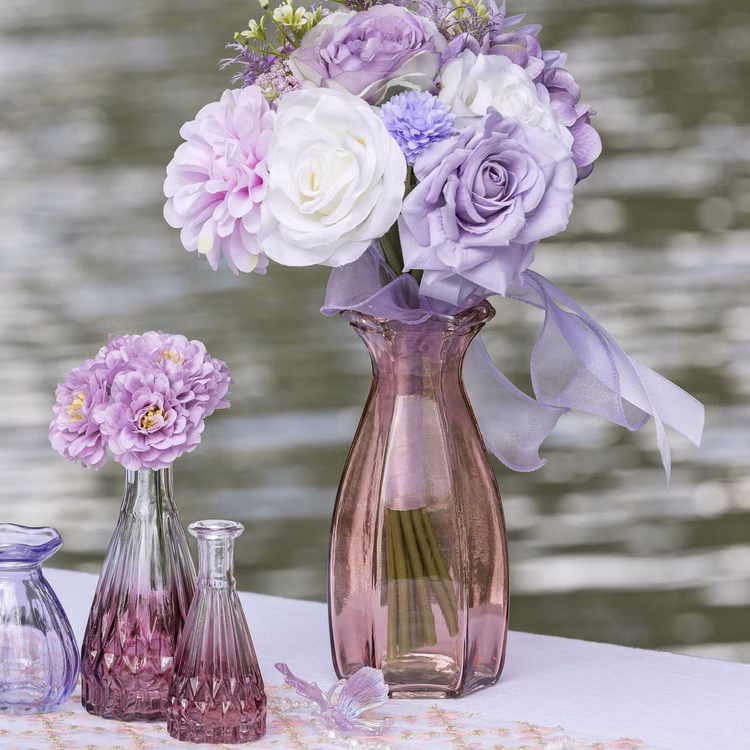 2 Glasvasen mit Rosa Farbverlauf 14,5 & 10,7 cm Tischdeko Hochzeit Geburtstag Glasvasen-Set Blumenvase Tisch-Deko dekorativ Vasen-Set Wohnaccessoire Zwei Glasvasen mit rosa Farbverlauf als Tischdeko, dekoriert mit lila Blumen und auf einer festlich gedeckten Tafel arrangiert.
