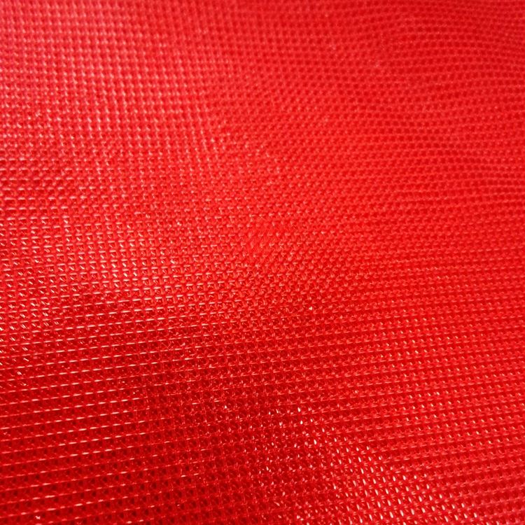 Roter Bodenläufer aus Polyester-Vlies leicht ausgerollt auf weißem Hintergrund, ideal für Events und Feiern.