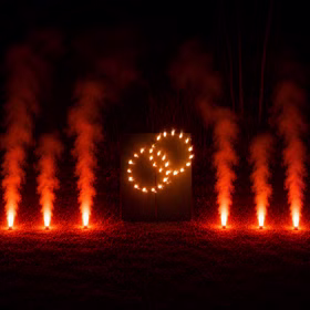 Lichterbild Brennende Ringe mit rotem Bengalfeuer Geschenkidee Hochzeit Verlobung Heiratsantrag Goldene Hochzeit Jubiläum Brennende Eheringe mit sechs Bengaltöpfen bei Dunkelheit.